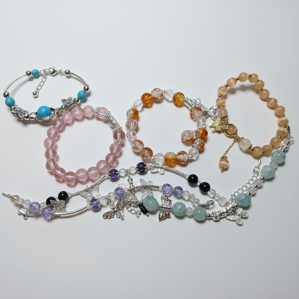 Charm bracelets in pink and amber tones on white background